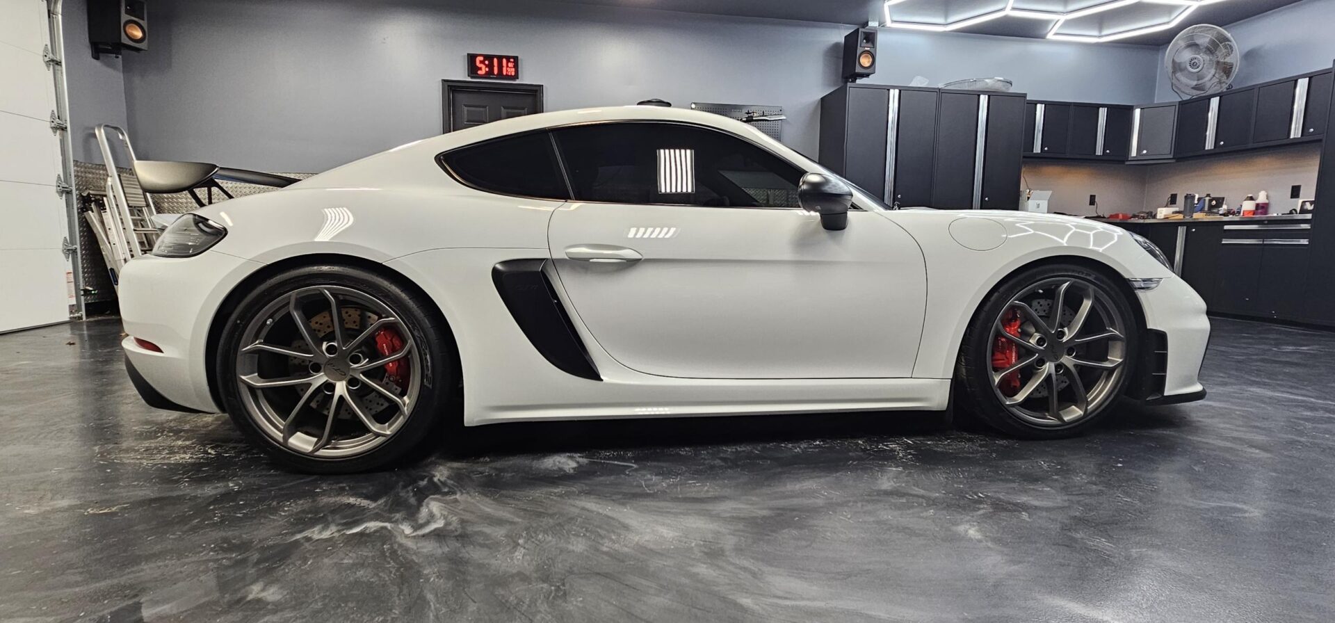 A white car parked in a garage with black trim.