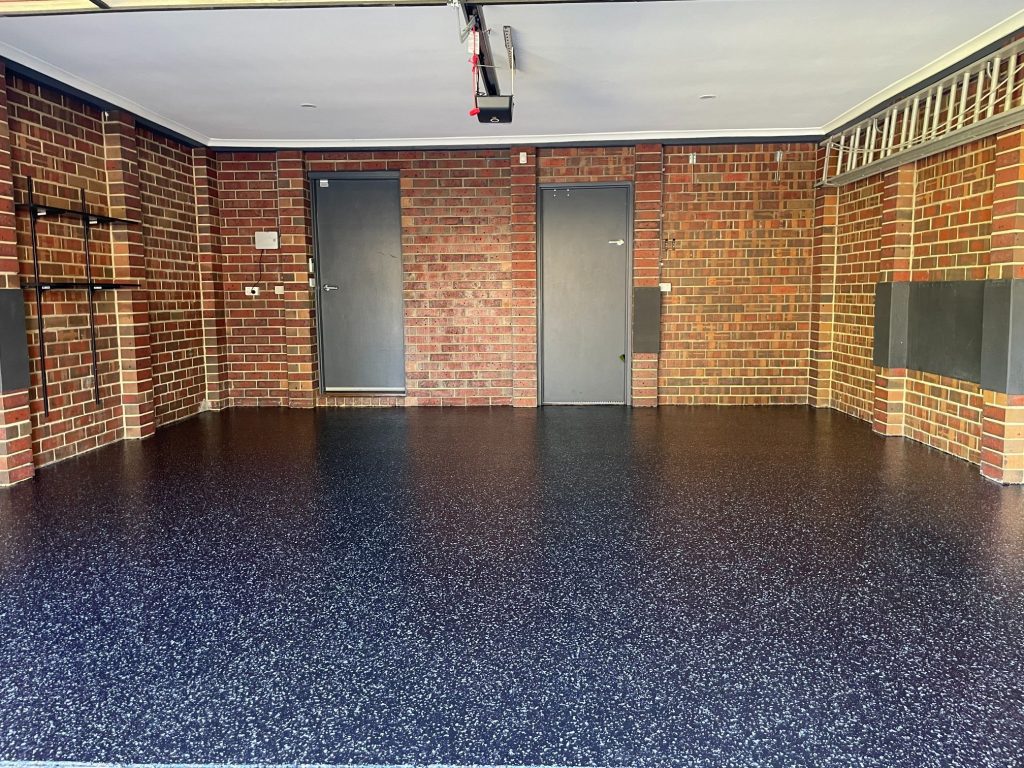 A garage with black floor and brick walls.