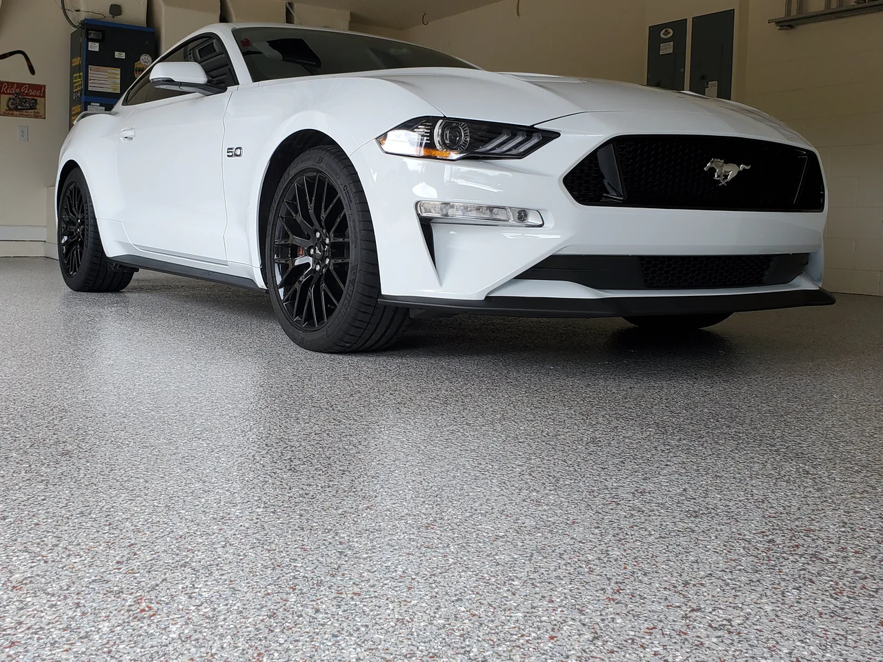 A white car parked in front of a garage.